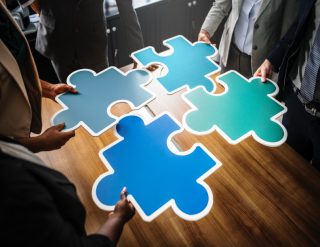 Large puzzle pieces being put together on a boardroom table