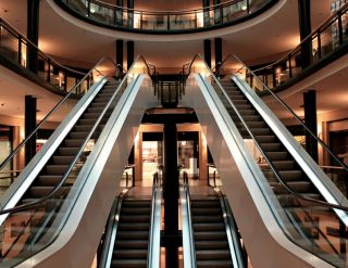 The inside of a shopping mall with escalators.