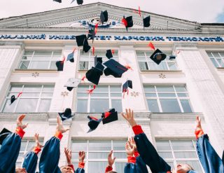 Students are throwing caps in the air to celebrate their their graduations.